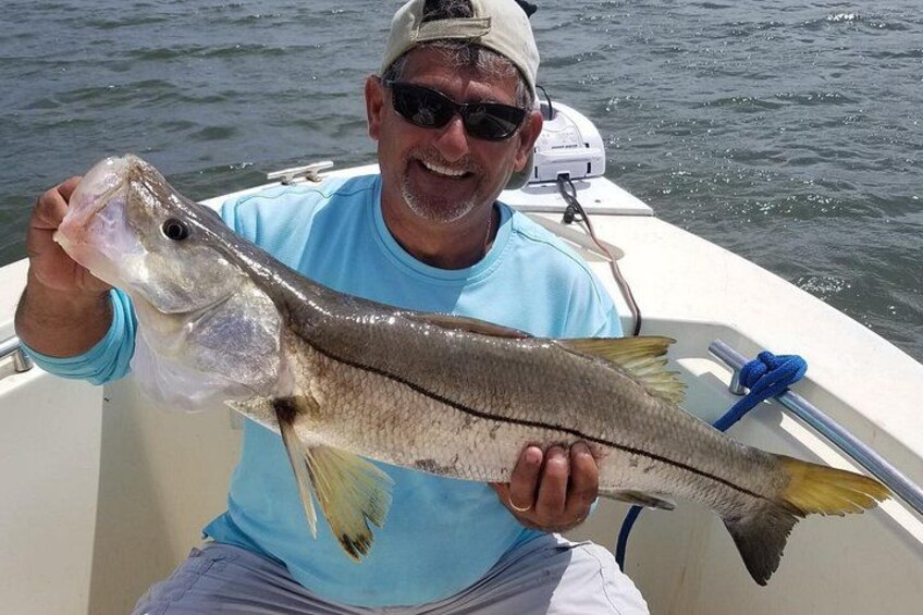 A person holding a fish on a boat. 1
