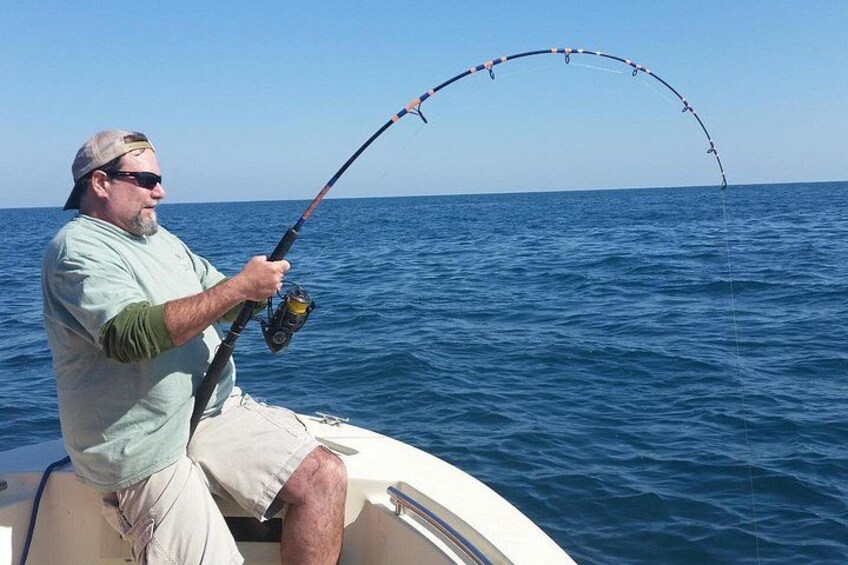 A man fishing on a boat in the ocean. 2