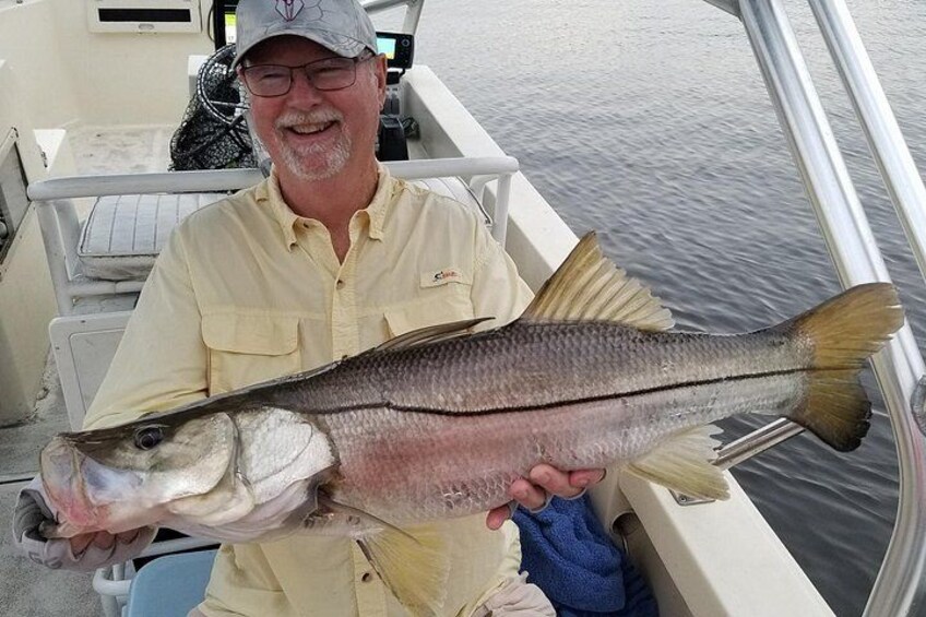 A person holding a large fish on a boat. 3