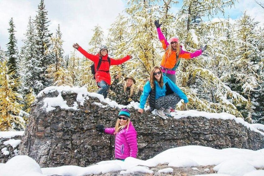 A group of people on a snowy mountain with trees in the background. 5