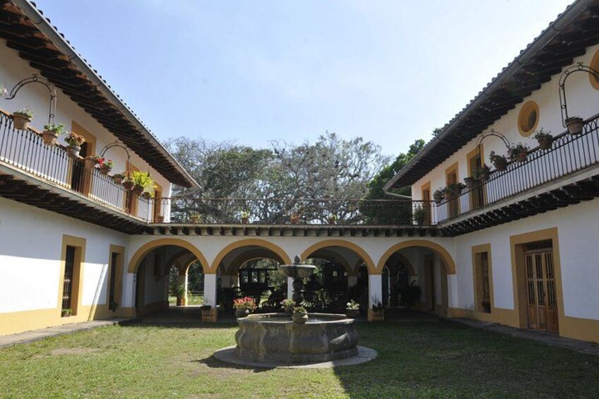 A courtyard with a fountain, arches, and potted plants. 5