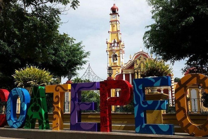Colorful letters spelling 'DONEPE' in front of a building with a clock tower. 4