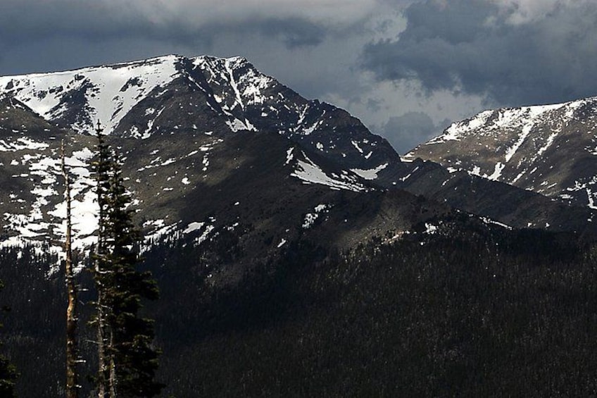 A mountain range with snow-covered peaks and a forested foreground. 3