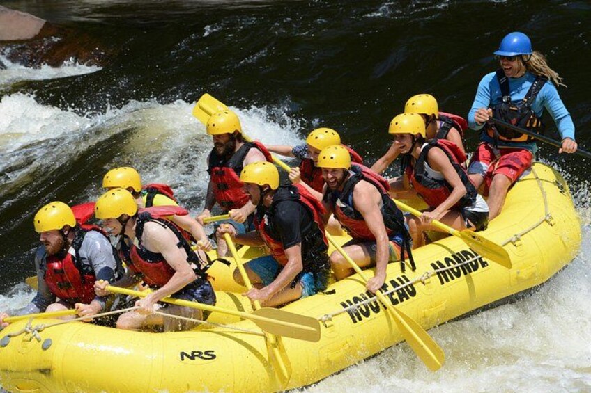 A group of people in a yellow raft navigating a river. 2
