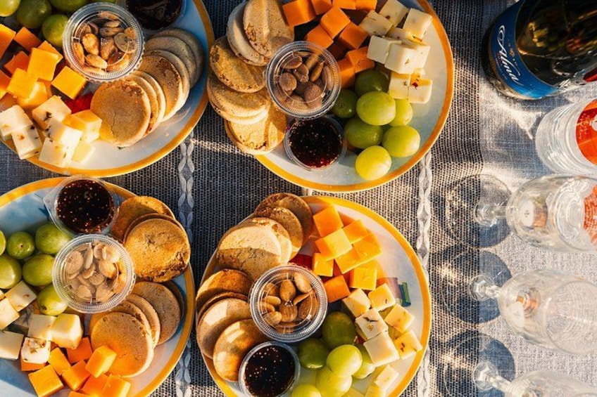 A table with various food items including cheese, crackers, and grapes. 3
