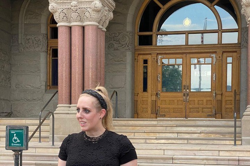 Eine Frau steht vor einem Gebäude mit verzierten Säulen und einem großen Bogenportal. 2