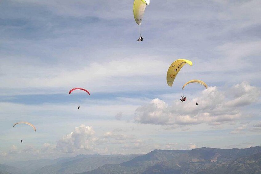 Paraglidingflygare på himlen med berg i bakgrunden. 4