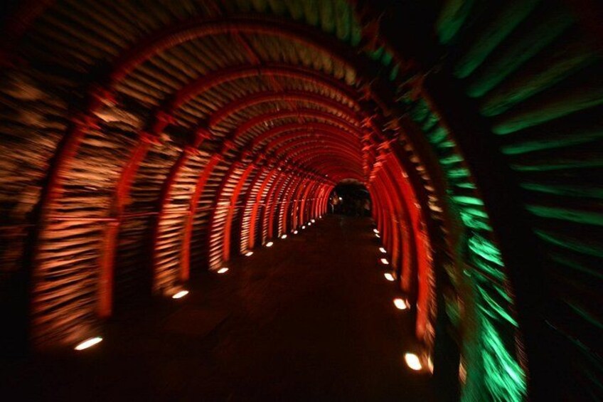 A tunnel with a curved ceiling and red lighting. 5