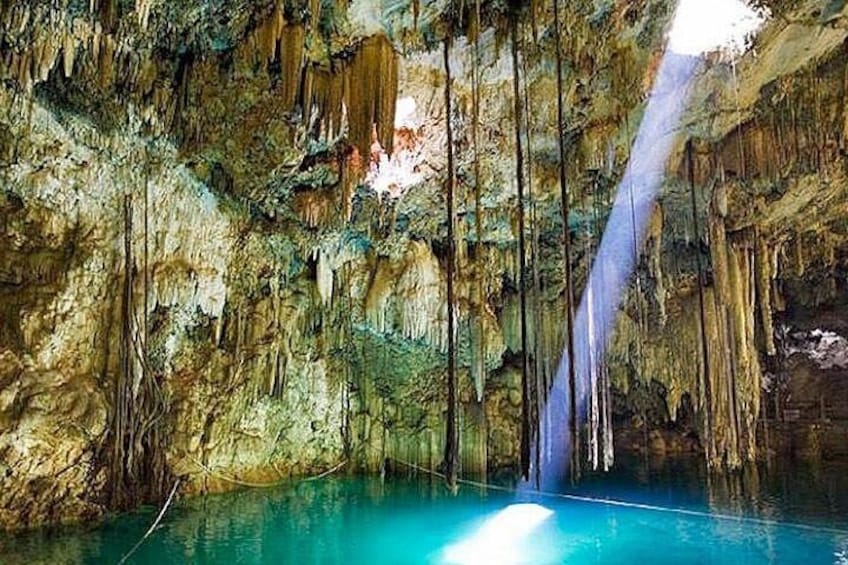 A cave with stalactites and stalagmites, a pool of water, and a waterfall. 3