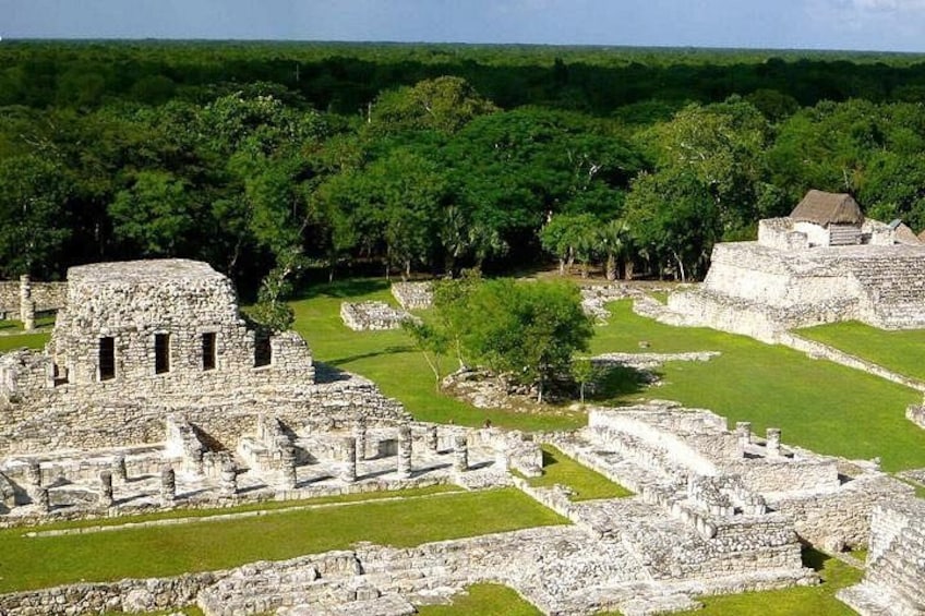 Ancient stone ruins with a large pyramid and smaller structures, surrounded by dense green forest. 4