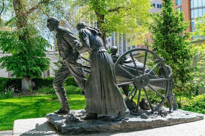 A statue of a man and a woman with a large wheel. 2