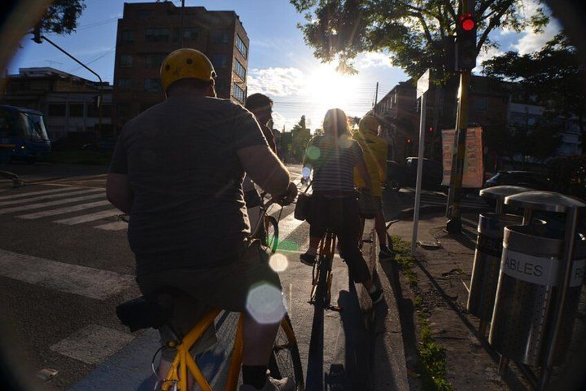 A street scene with cyclists, a traffic light, and buildings in the background. 3