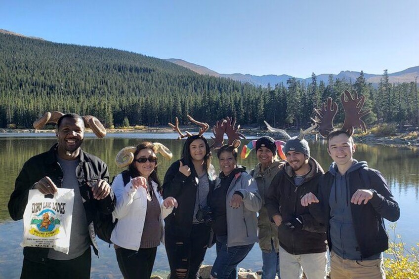 A group of people by a lake with mountains in the background. 5