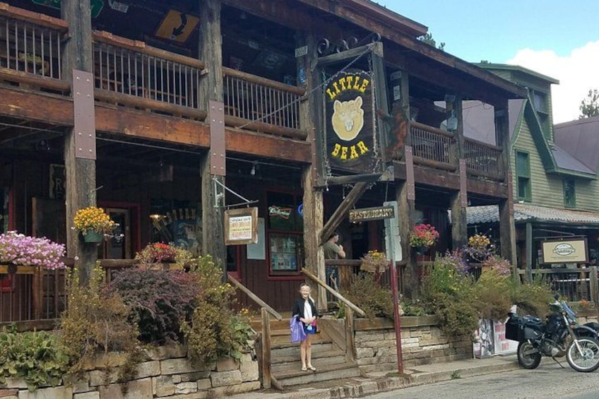 A wooden building with a sign reading 'Little Bear Restaurant.' 1