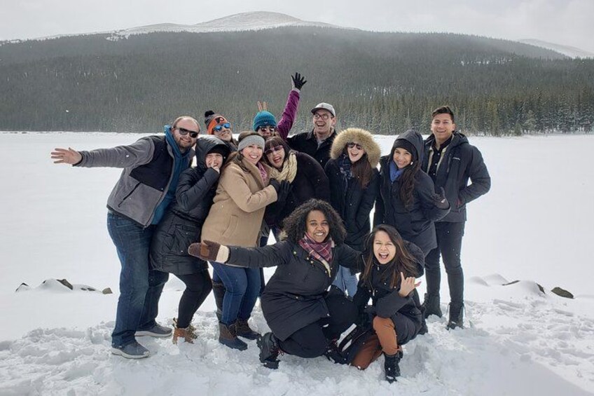 A group of people posing on a snowy landscape with mountains in the background. 4