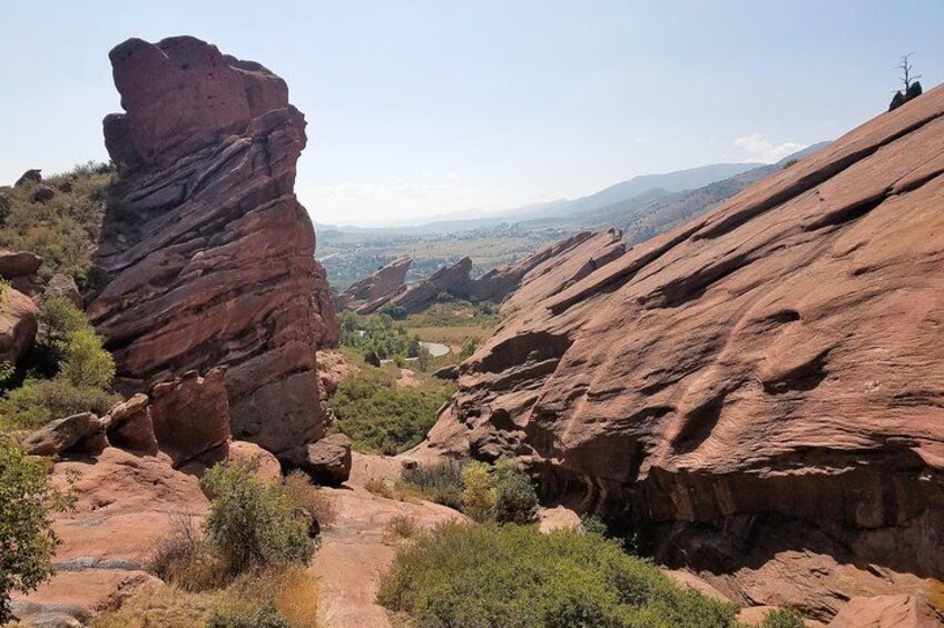 A rocky landscape with a prominent rock formation and a valley in the background. 2