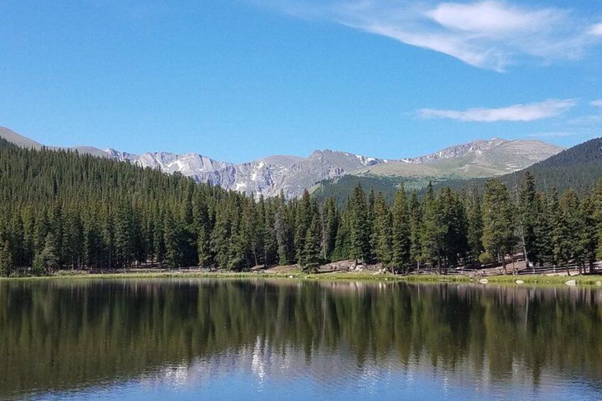 A calm lake surrounded by dense forest and mountains. 3