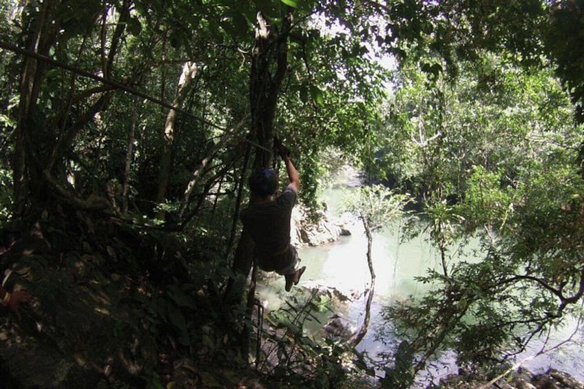 A person navigating a forested area with a river. 3