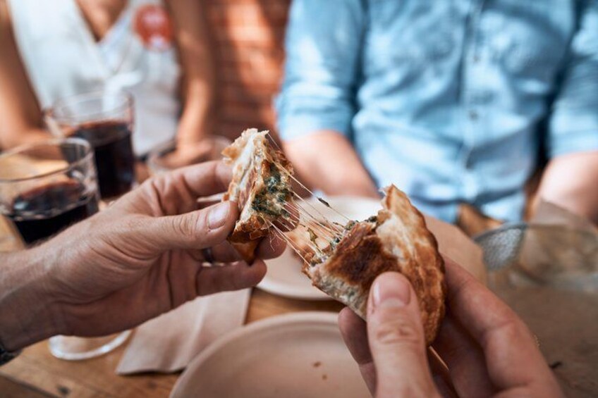 Une personne tenant un sandwich dont on peut voir la garniture verte. 5