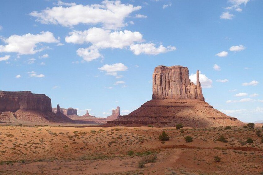 A desert landscape with prominent rock formations and sparse vegetation. 2