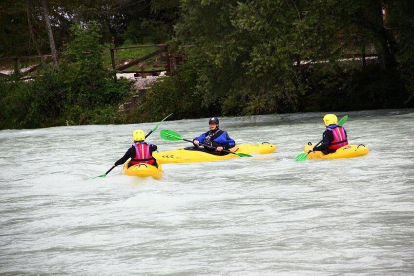 Three kayakers on a river surrounded by trees. 3