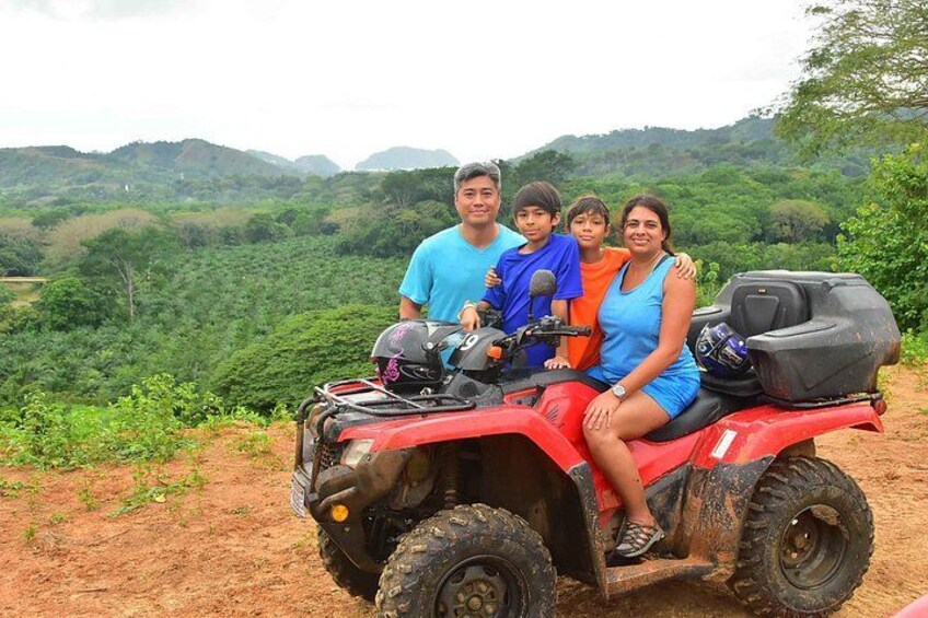 Un grupo de personas en un vehículo todo terreno rojo en un paisaje montañoso y verde. 2
