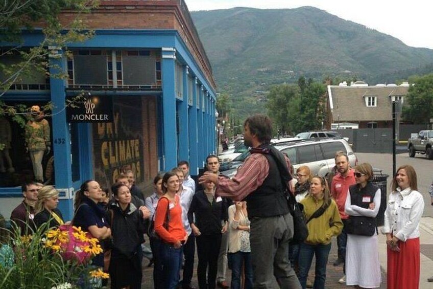 A group of people standing in front of a building with a sign that reads 'Moncler Climate.' 2
