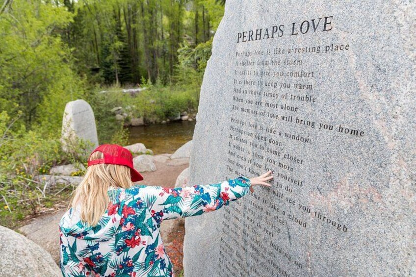 A person writing on a large stone with text. 5