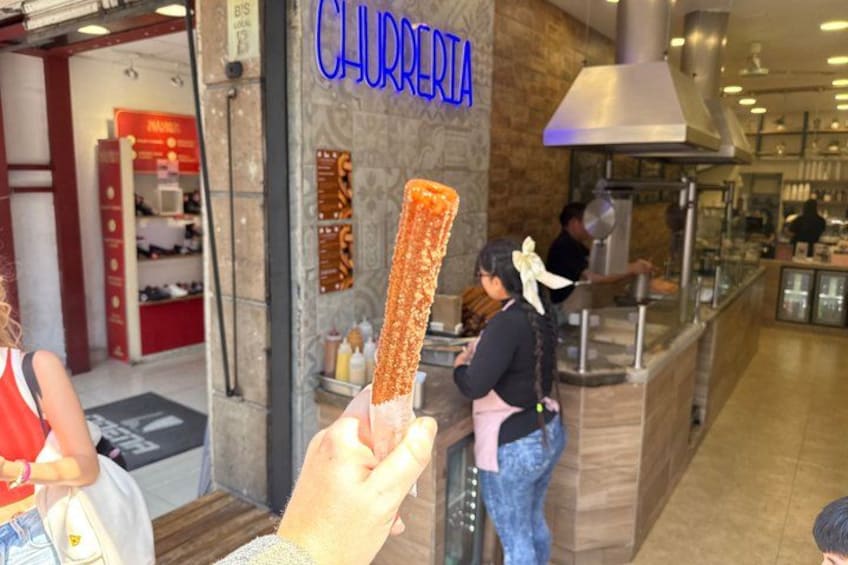 Un chiosco di churros, con un churro sollevato. 3