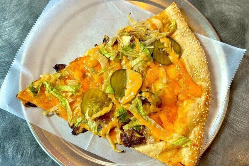 A slice of pizza with cheese, jalapeños, and lettuce on a paper plate. 2