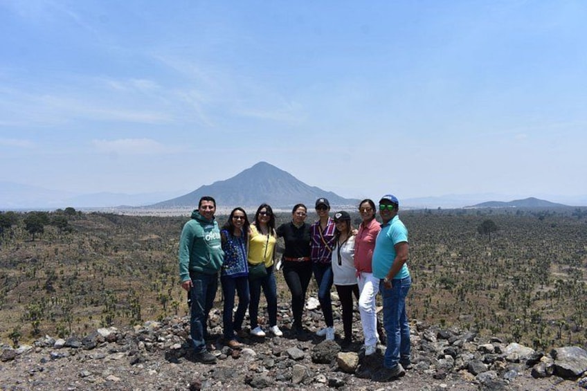 A group of people standing on rocky terrain with a mountain in the background. 4