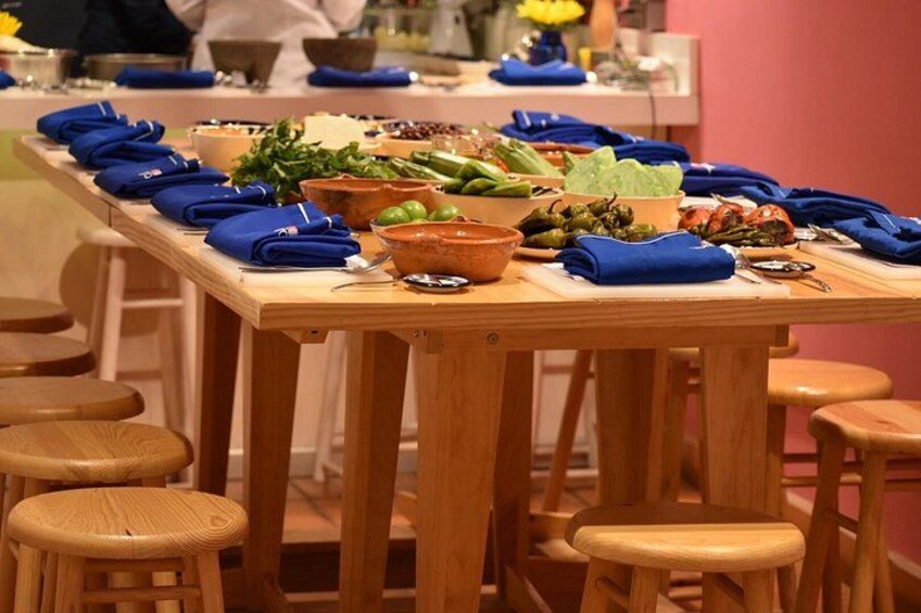 A wooden table with various dishes and blue napkins. 4