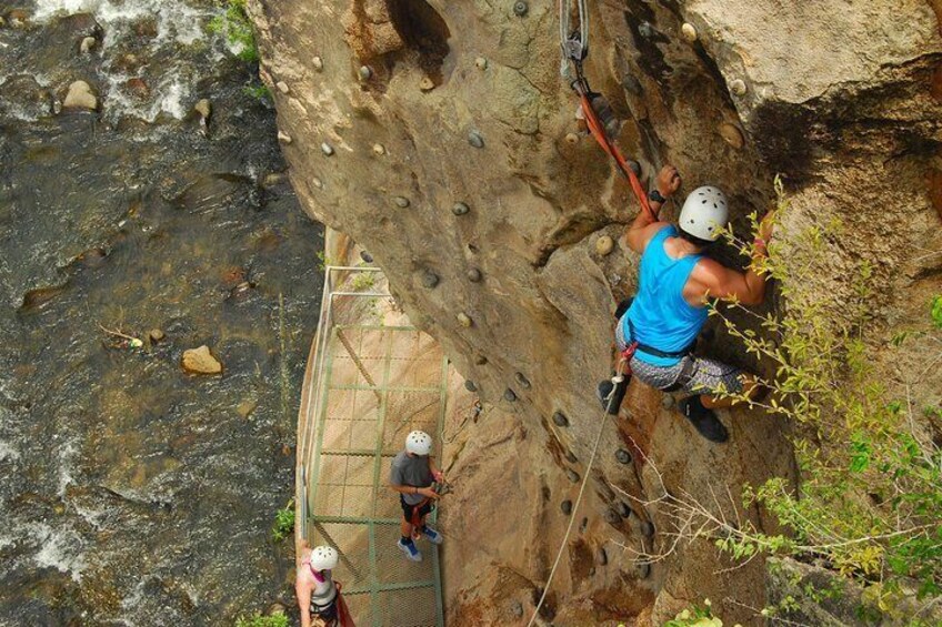 A person climbing a rock face with a rope. 1
