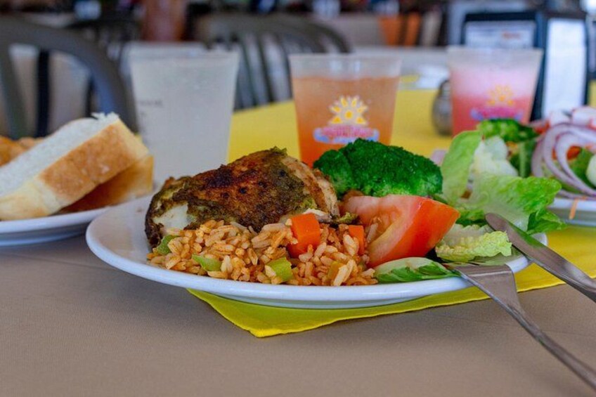 A plate of food with rice, vegetables, and a piece of fried chicken, along with a drink and a sandwich. 5