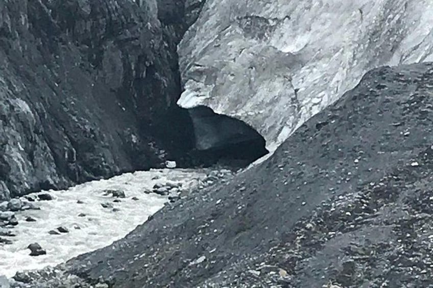 A glacier with a crevasse and a rocky foreground. 1