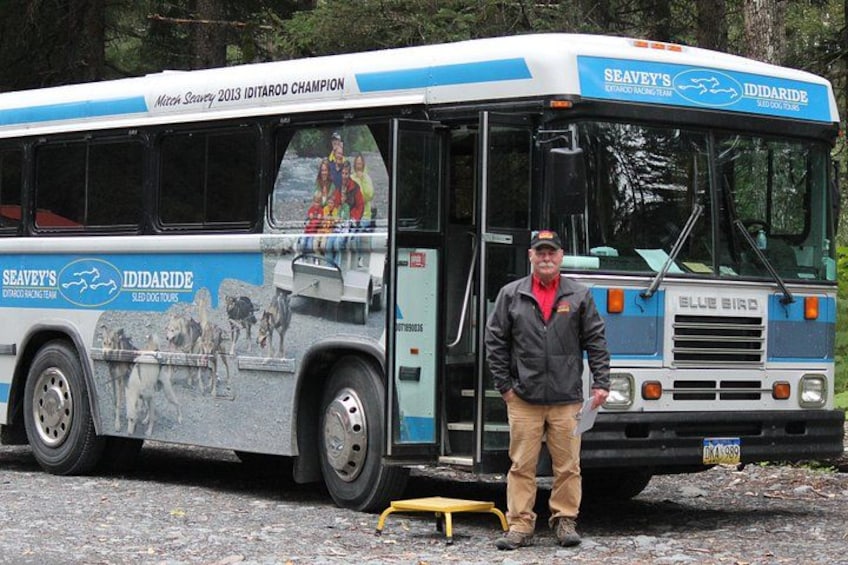 En mand står ved siden af en bus med reklamer for Seavey's og Ididaride. 3