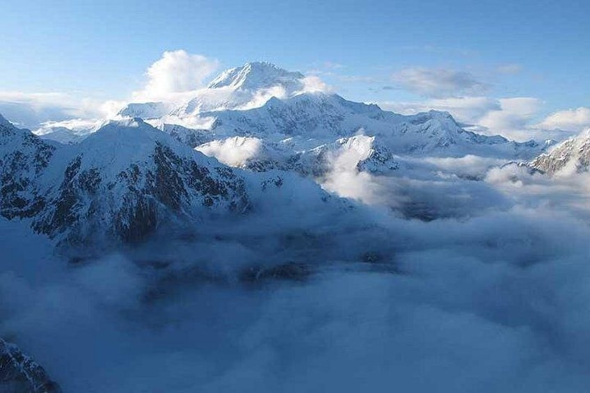Une chaîne de montagnes enneigée, avec des nuages en contrebas. 3