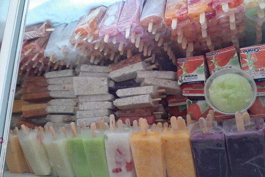 Een overzicht van verschillende ijsstokjes en sorbets in een vriezer. 4