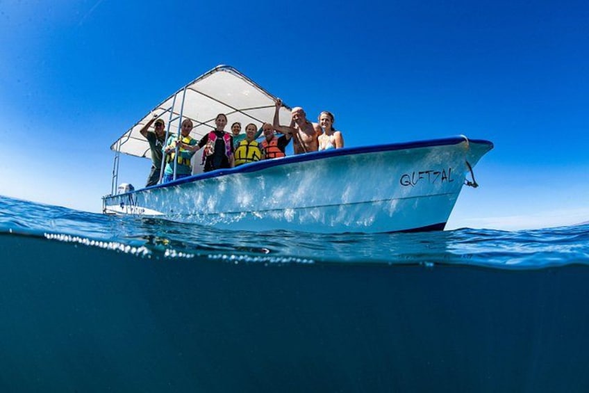 Een boot met mensen die reddingsvesten dragen op het water. 3