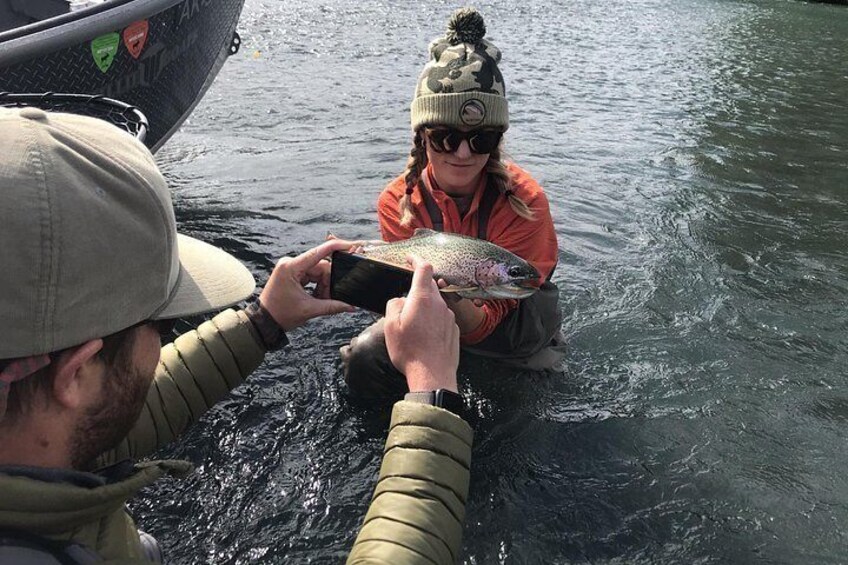 Zwei Personen in einem Boot halten einen Fisch. 3