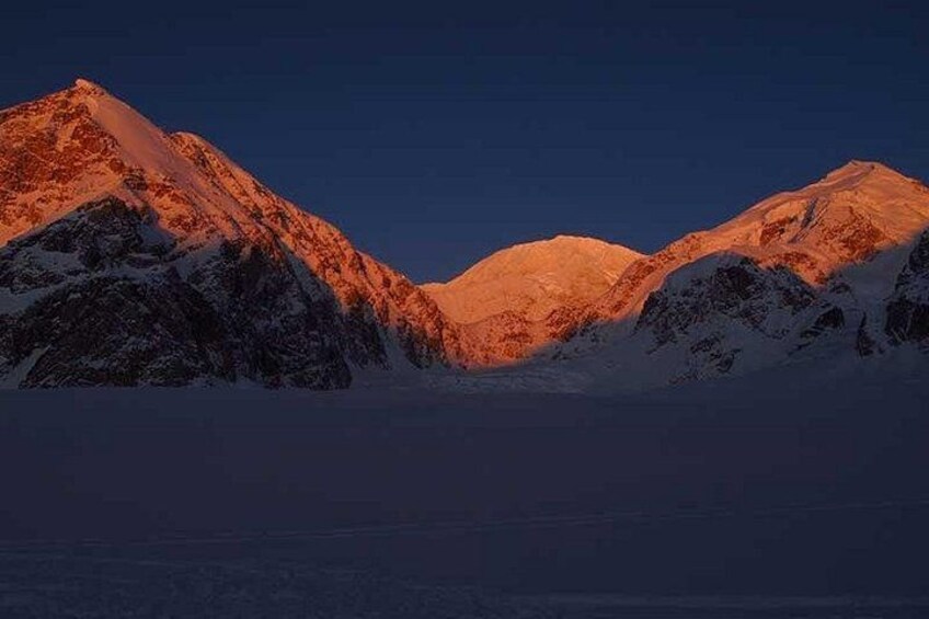 A mountain range at sunset with snow-covered peaks and a clear sky. 2