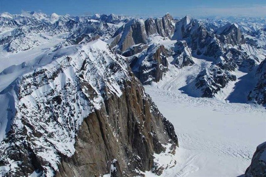 A snow-covered mountain range with sharp peaks and rugged terrain. 4