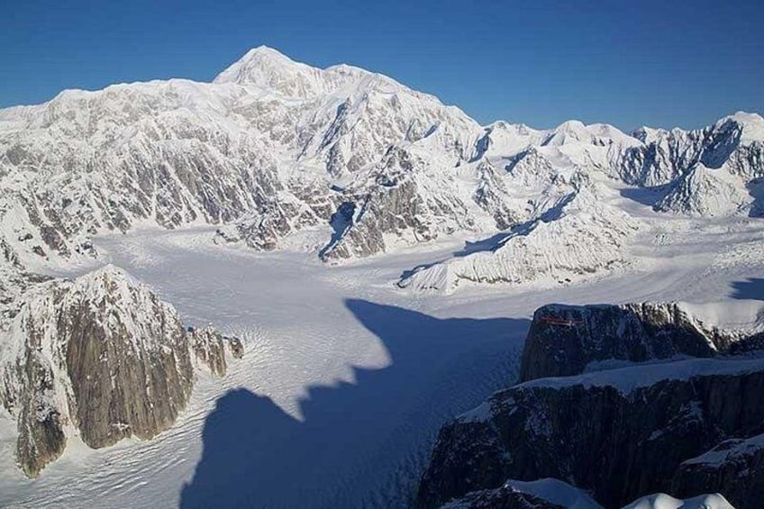 A snow-covered mountain range with sharp peaks and a glacier. 4