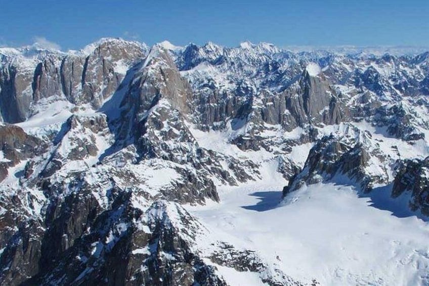 A snow-covered mountain range with sharp peaks and rugged terrain. 3