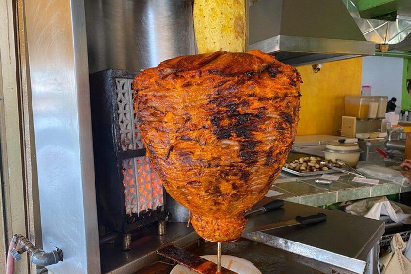 Een grote bradenpan met een draaiende braadspit, een metalen grill en kookgerei. 2