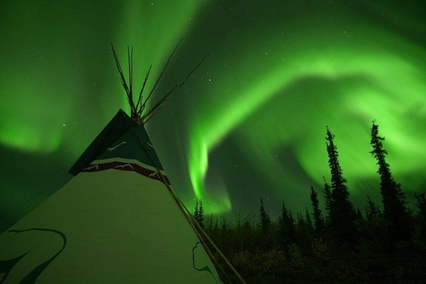 A teepee with a green aurora in the background. 5