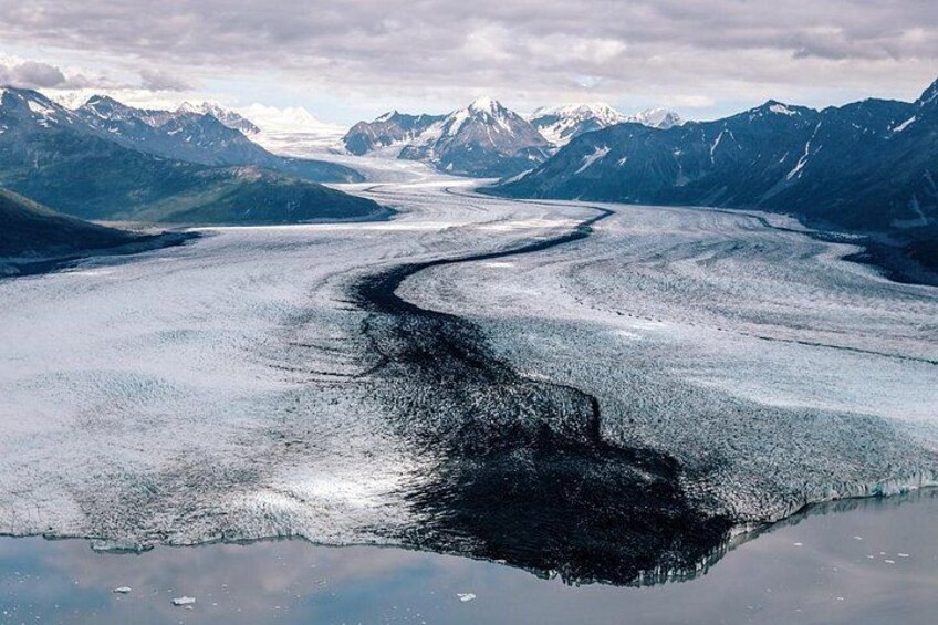 Un glaciar con una grieta, rodeado de montañas. 3
