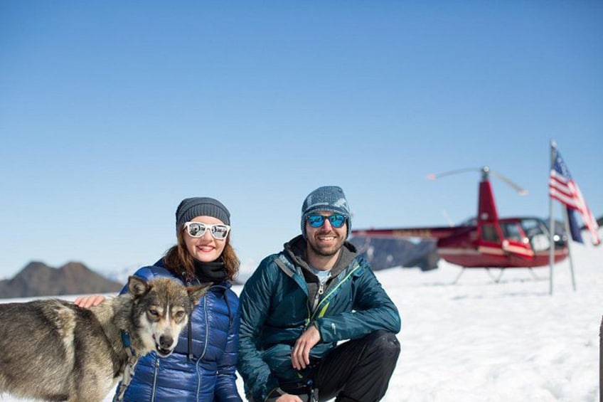 A person with a dog and a helicopter in a snowy landscape. 1