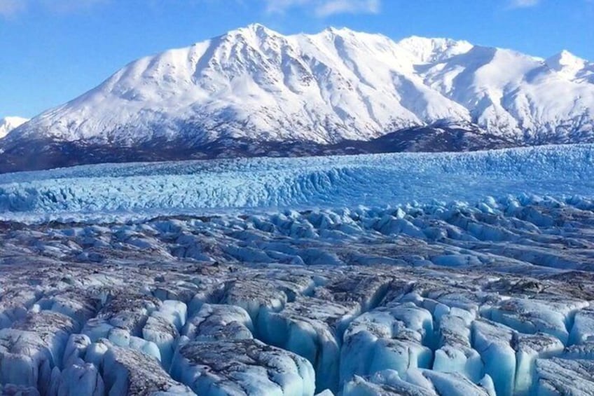 Un glaciar con montañas nevadas al fondo. 3