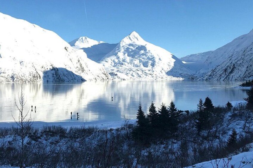 Een met sneeuw bedekte meer met bergen op de achtergrond. 5